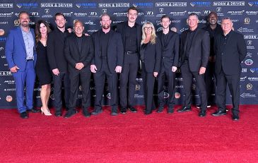 Group of people posing on a red carpet at an event.