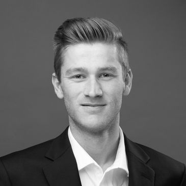 Professional headshot of a smiling man in a suit.