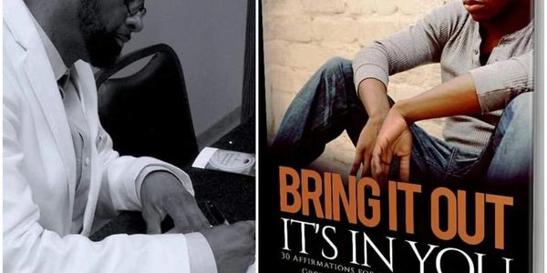 Person writing and motivational poster of a man sitting with 'BRING IT OUT IT'S IN YOU' text.