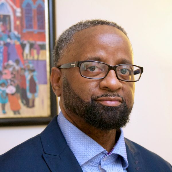 Man with glasses and beard in a suit.