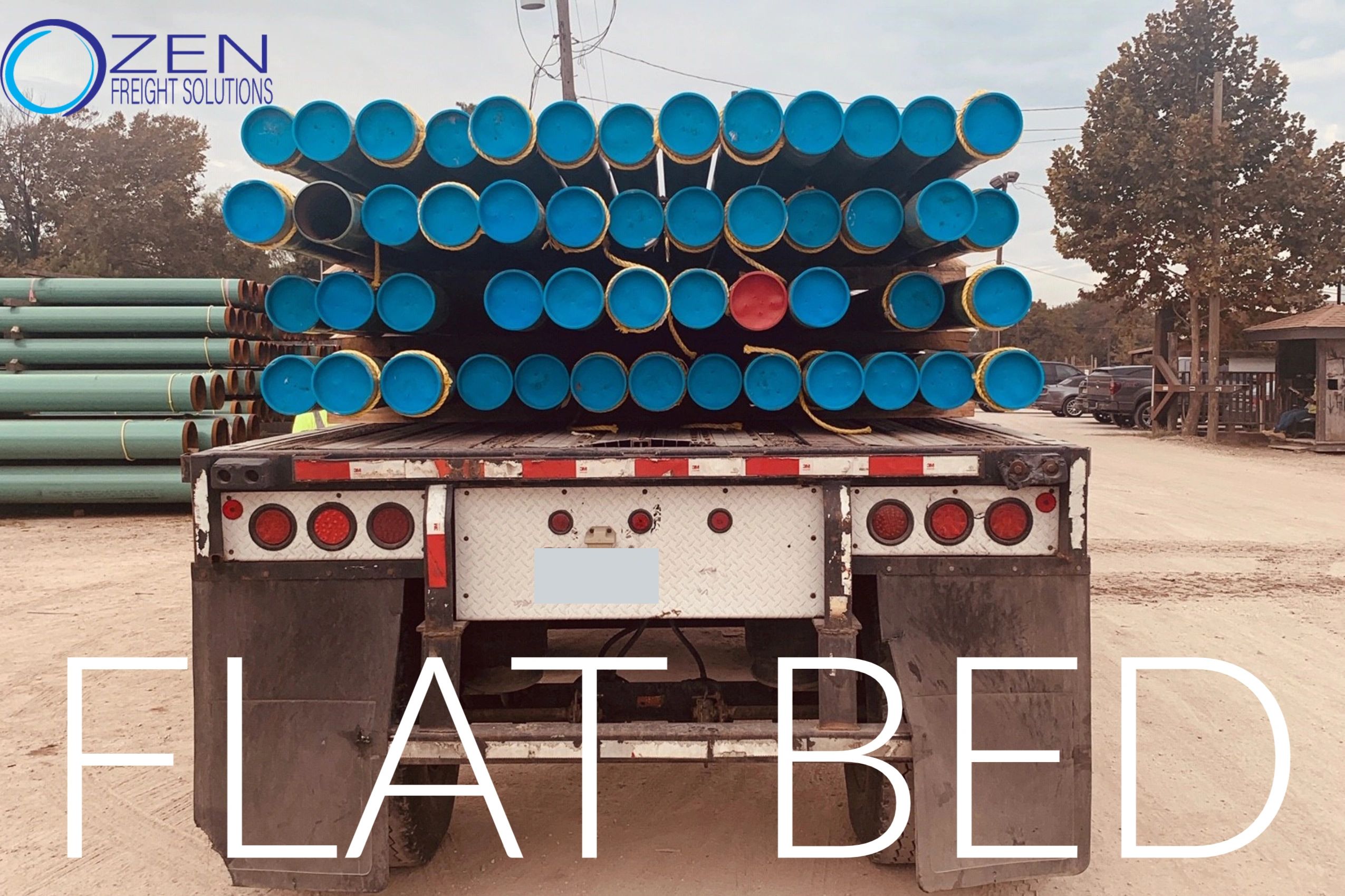 Rearview of a flatbed truck hauling tubes