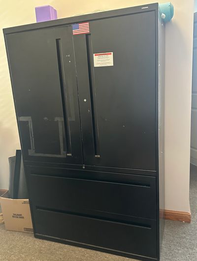 Black office cabinet with two doors and two drawers.