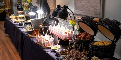 A buffet setup with various dishes and warm lighting.