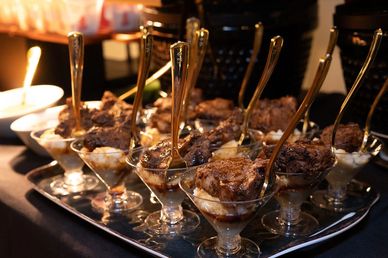 Dessert cups with spoons on a tray.