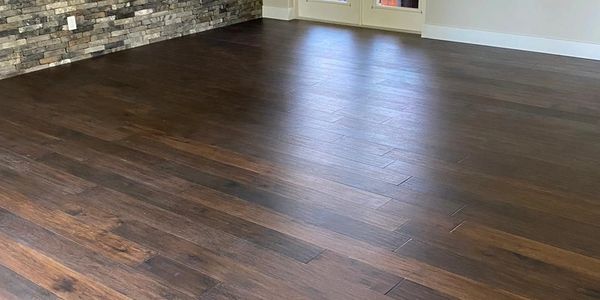 Shades of dark brown hardwood floored empty room after a thorough hard surface cleaning.