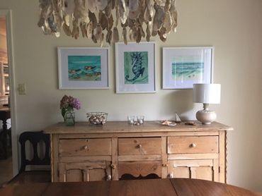 Watercolor art hanging on interior wall in beach home. Seahorse and sandpipers.