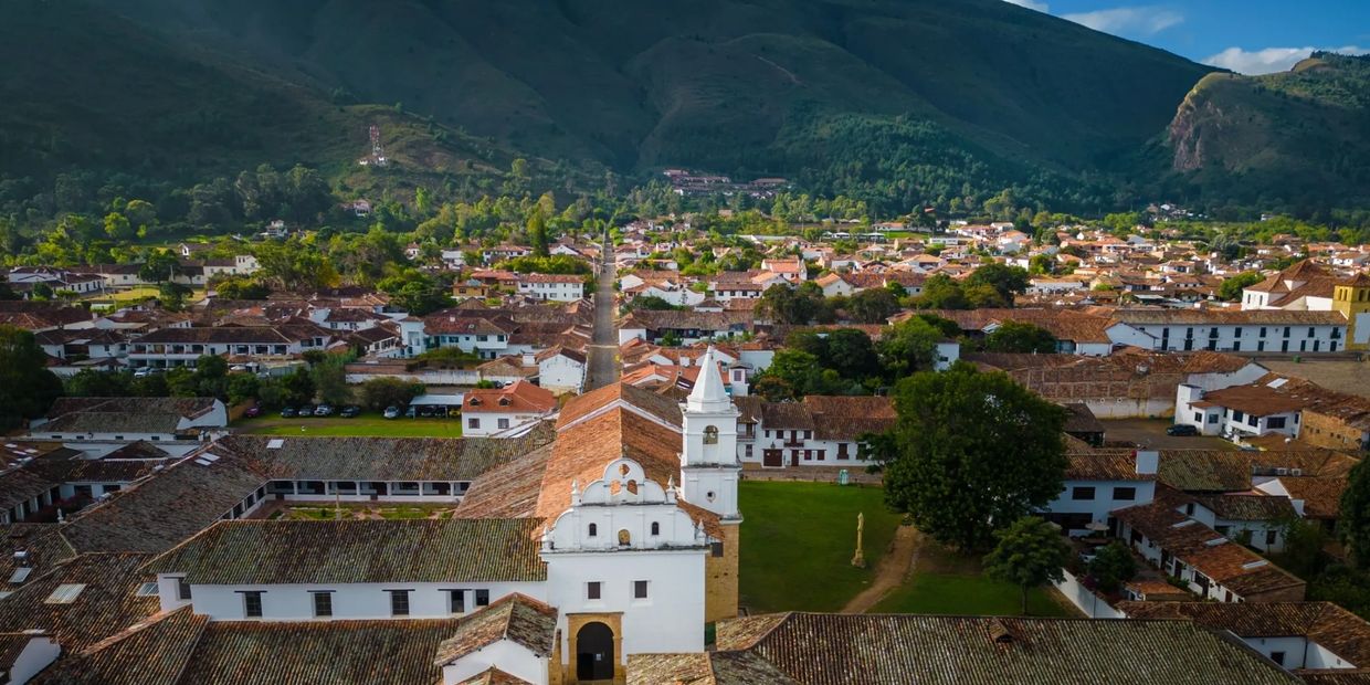 Aerial view of a historic town with colonial-style buildings and a central church.