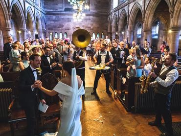 Full Church with bride and groom in foreground and band playing around them