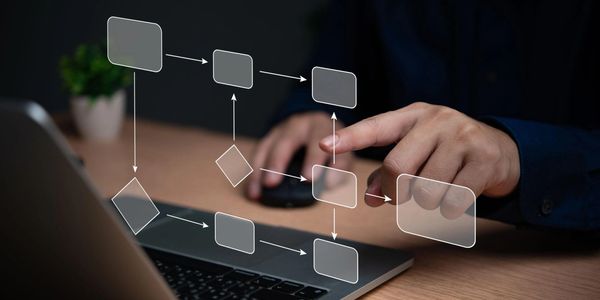 Person interacting with a virtual flowchart projected over a laptop keyboard.