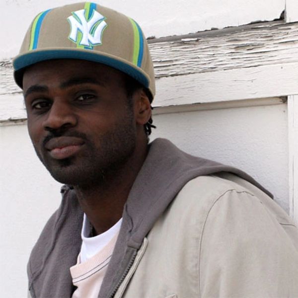 Man wearing a beige jacket and a colorful cap with NY logo.