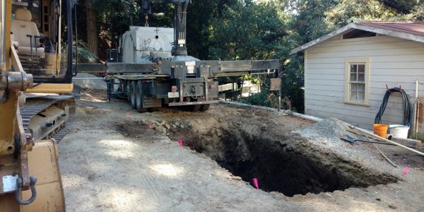 A septic tank being set in the excavation in Castro Valley, CA. Concrete septic tank used here.