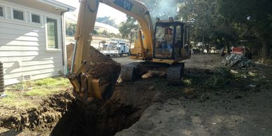 An excavator digging a septic tank hole.
