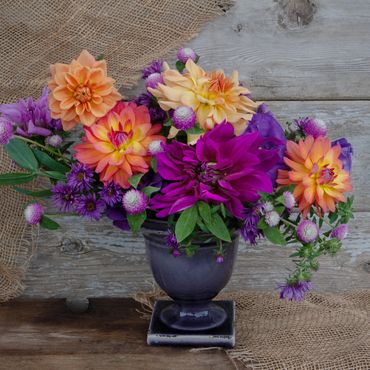 Late summer compote with local dahlias, lisianthus, gomphrena, and asters in vibrant orange and purp
