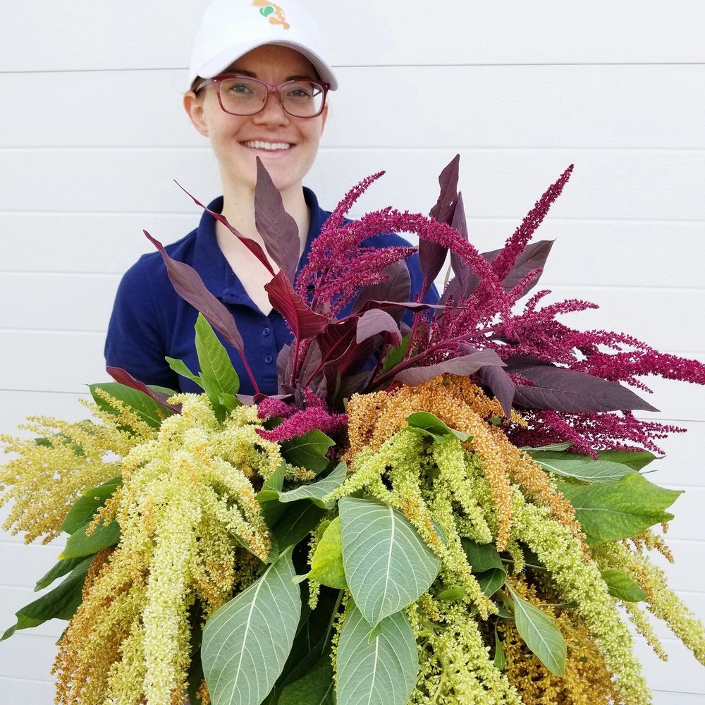 Smiling woman holding multicolored amaranthus blooms