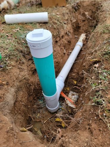 Installed PVC pipes in a dug trench for underground plumbing.