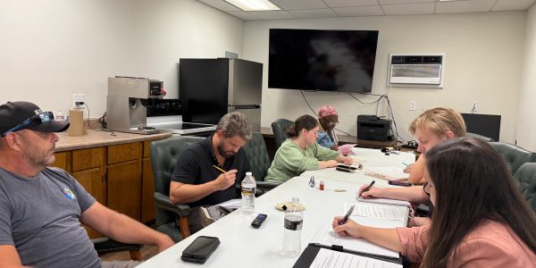 People writing notes in a meeting room.