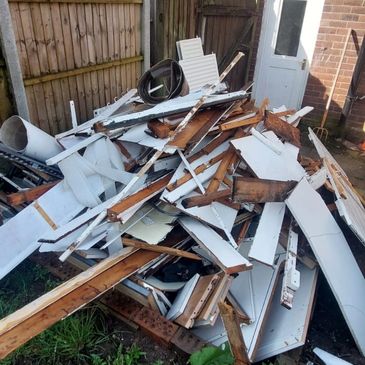 A GARDEN PILED UP WITH OLD WOOD. CUSTOMER HAS ASKED WASTE BUSTERS STAFFORDSHIRE TO REMOVE IT AND DIS