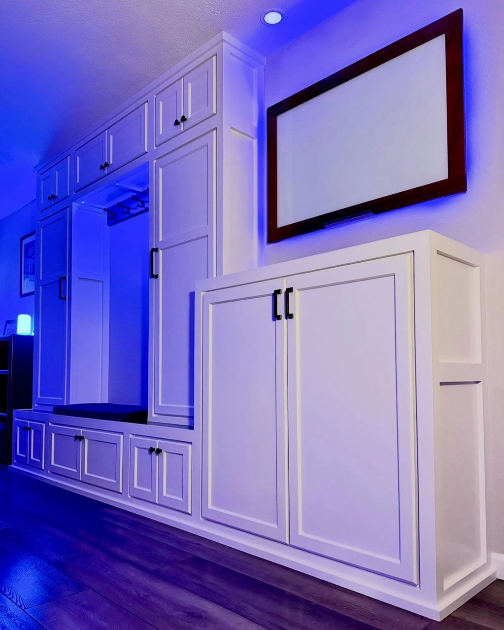 Entry built-in at night with app-controlled LED lighting on, backlighting the walnut-framed glass dr