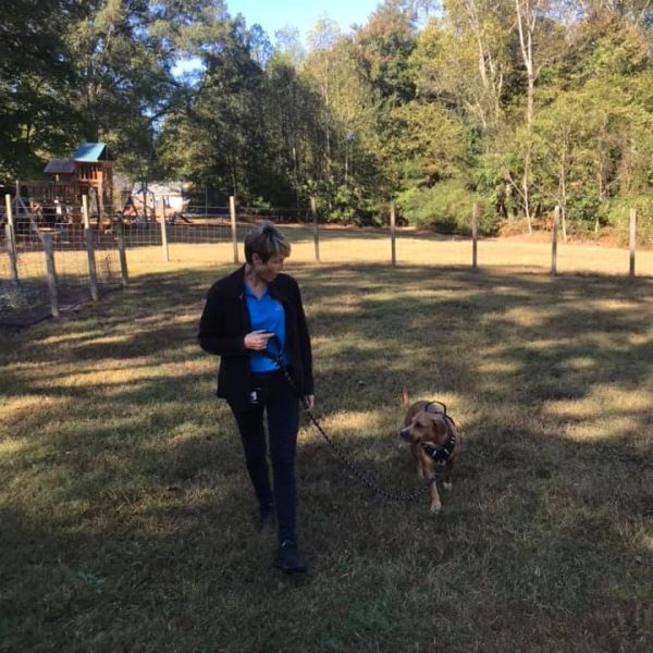 dog trainer walking outside with dog on a leash
