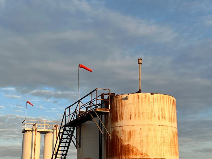 Orange H2S windsock mounted on a tank battery.