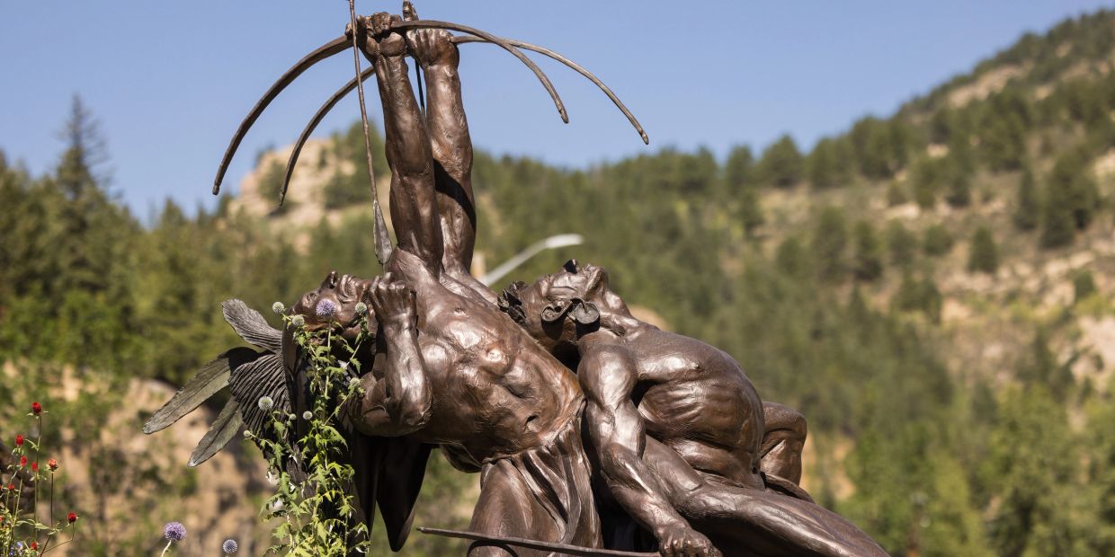 Bronze statue of two men aiming a bow and arrow.