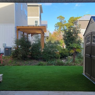 Synthetic turf in a backyard living space. Small yard.