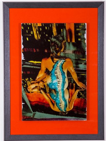 Woman facing away with blue piano painted down her back, seated on a mirror against a painted city