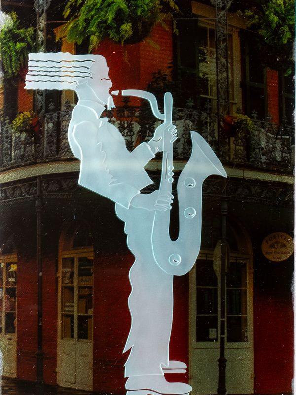 A saxophone player with hair flying back is seen playing music on the streets of New Orleans.