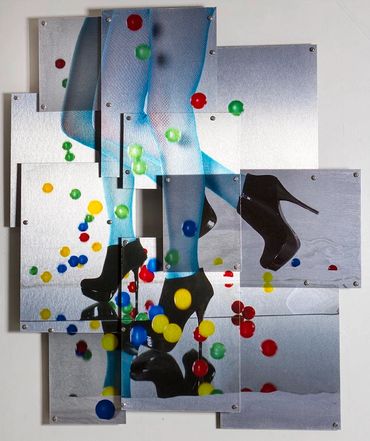 Photo of a woman's legs in blue tights, black high heels, colorful ping pong balls falling on mirror