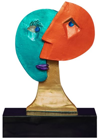 sculpture of two halves of a head. one teal, one red with purple lips on a gold neck, exaggerated ey