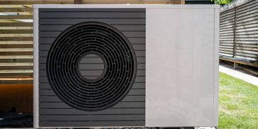 Air source heat pump outdoor unit beside a home