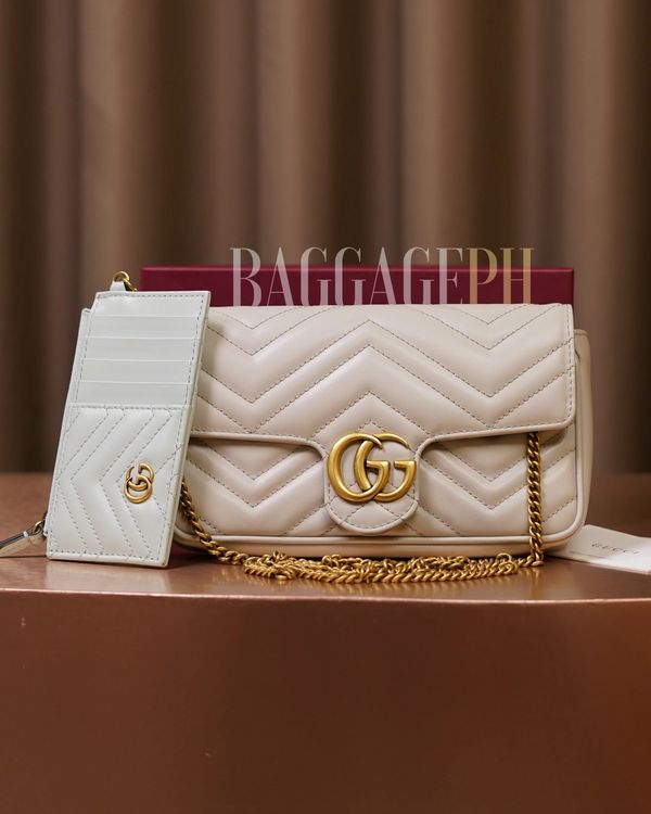 Elegant beige Gucci bag and matching cardholder with gold accents on display.