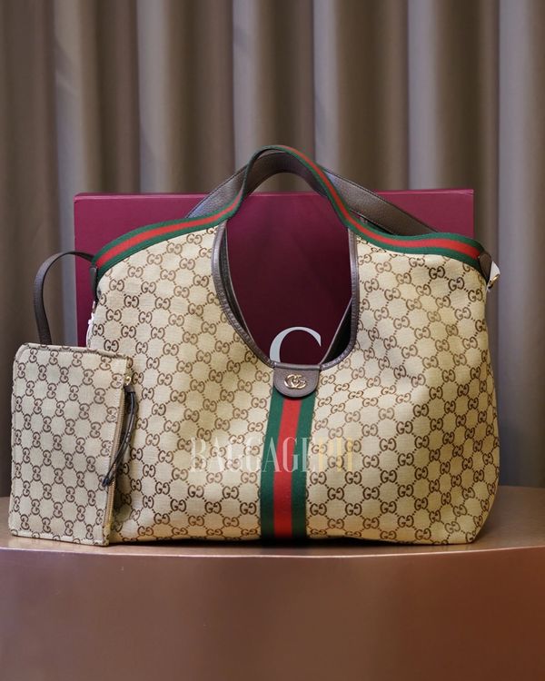 Luxury Gucci tote bag with matching pouch and signature green-red-green stripe.