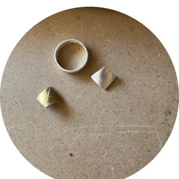 Three geometric metal rings on a textured surface.