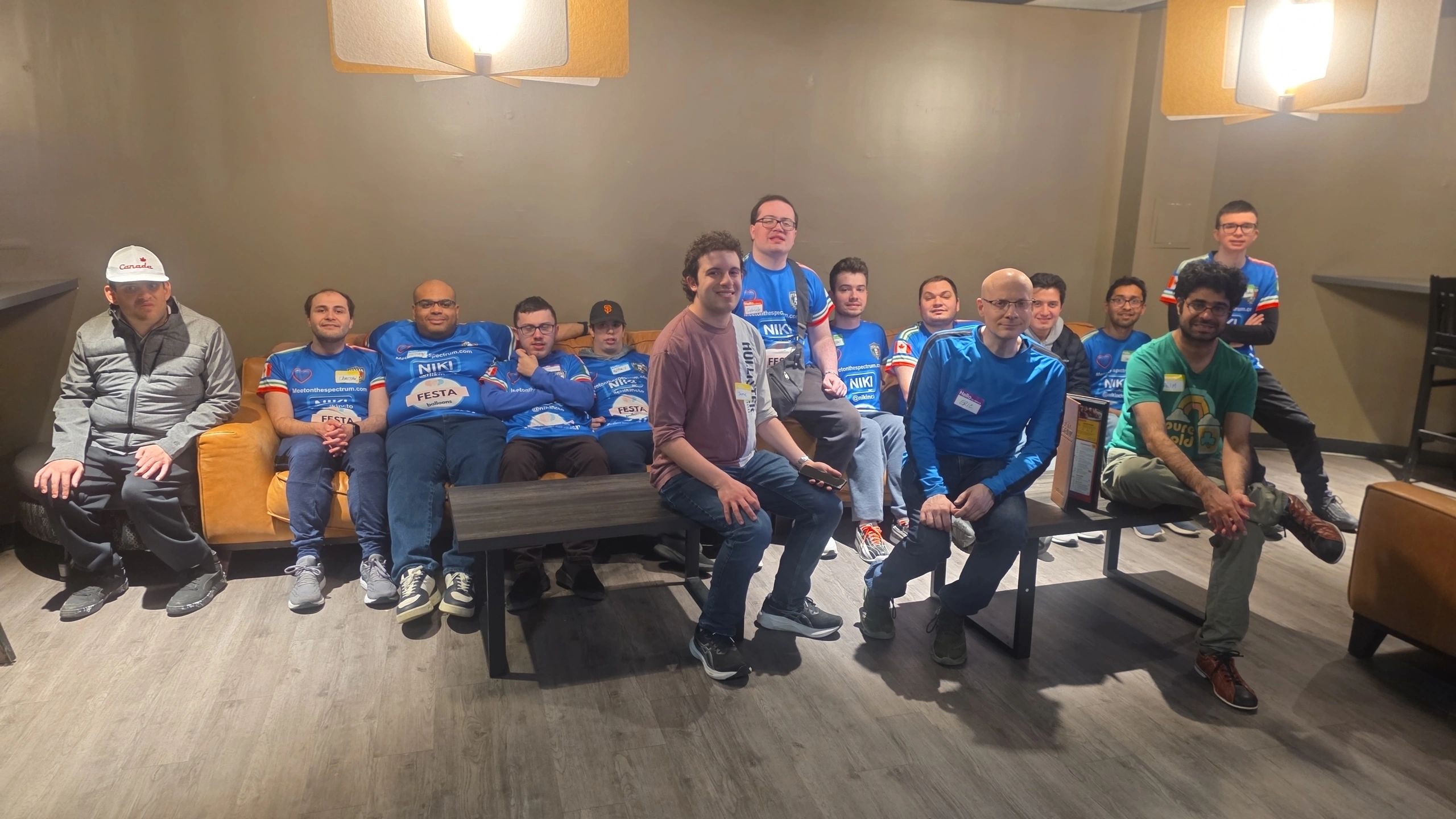 Group of men posing together indoors on couches and benches.