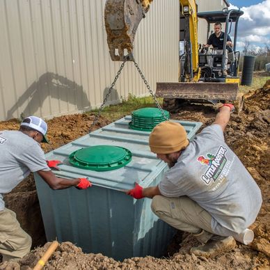 Workers installing a large tank with excavator.