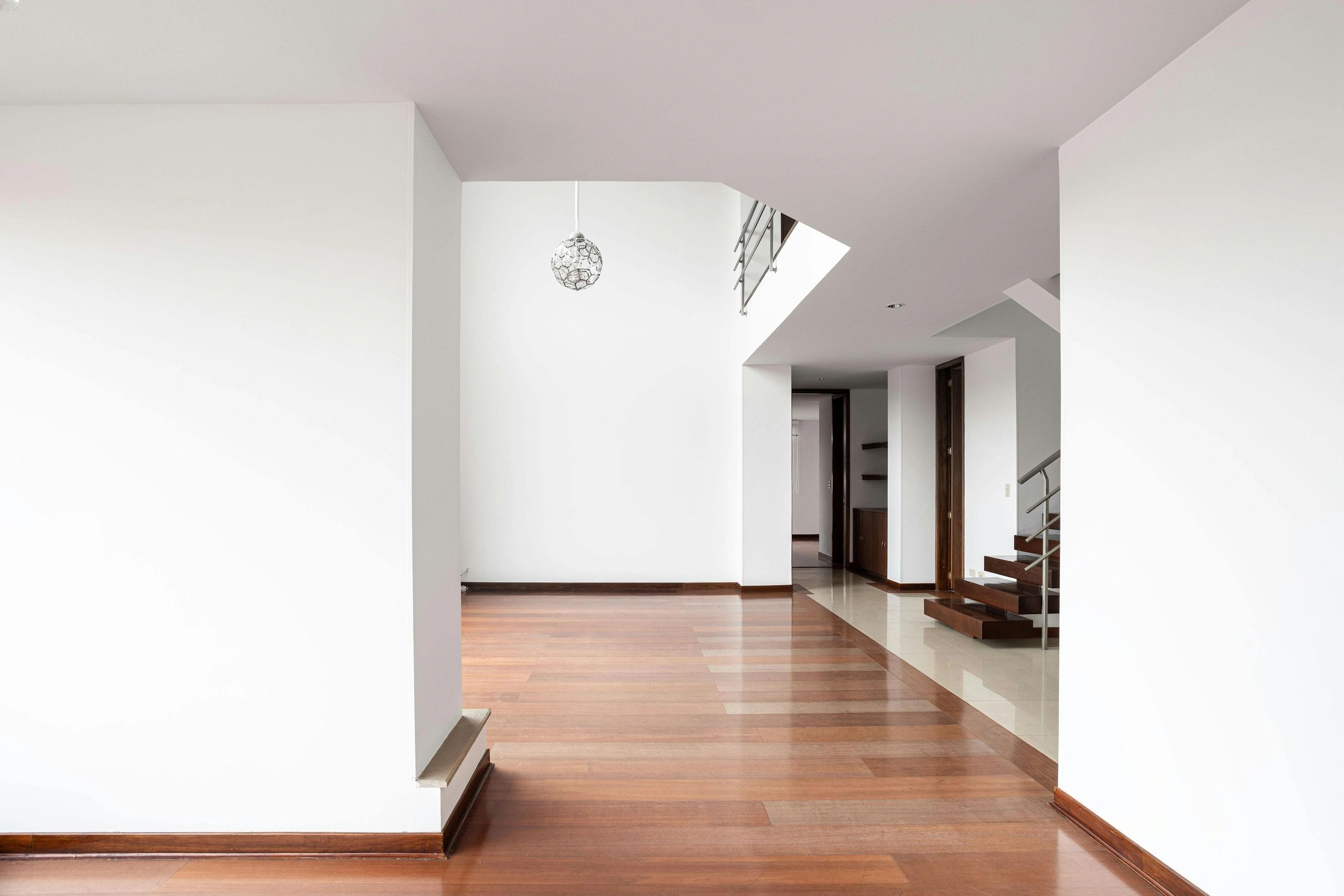 Modern empty room with wooden floor and staircase.