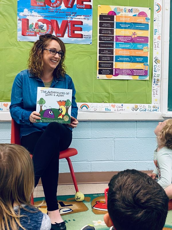 I am smiling and sharing my kids books and reading to a local preschool.