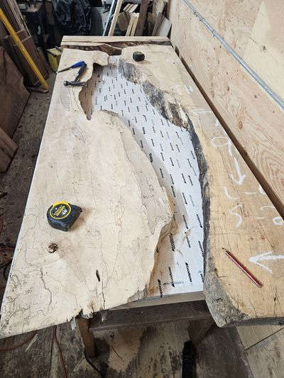 Wood slabs and tools on a workshop table.