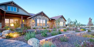 Stone house with landscaped garden and stone pathway during twilight.