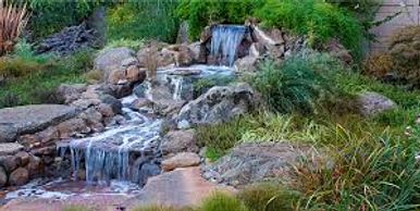 Small cascading waterfall in a natural garden setting.