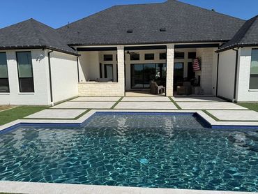 Modern backyard with a swimming pool and covered patio area.