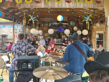Live music performance at a lively outdoor bar with engaged audience.