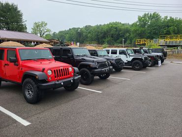 A lineup of Jeep Wranglers parked outdoors on a cloudy day.