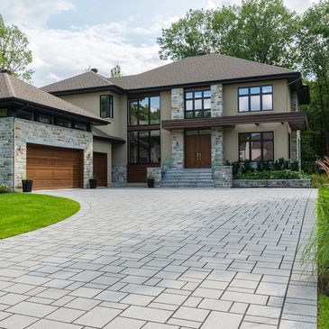 Modern two-story house with stone facade and spacious driveway.