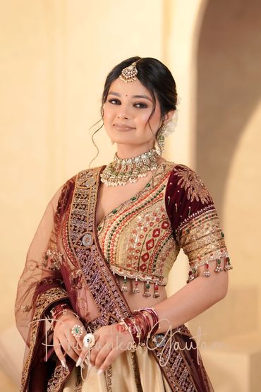 Woman in traditional Indian attire with intricate jewelry and embroidery.