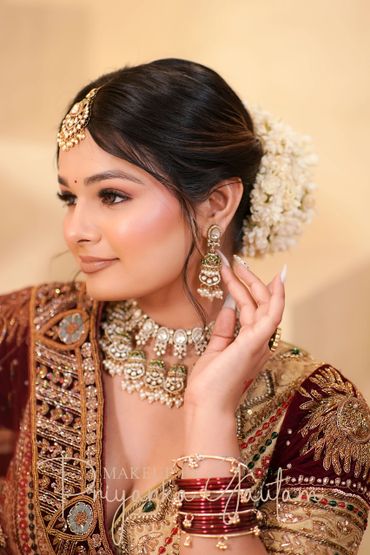 Bride with traditional jewelry and floral hair adornment.