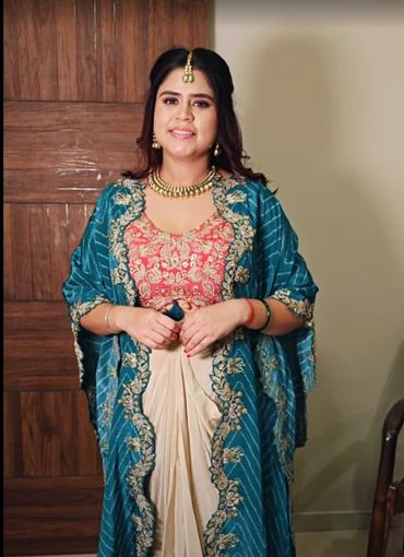 Woman in traditional Indian attire with intricate embroidery and jewelry.