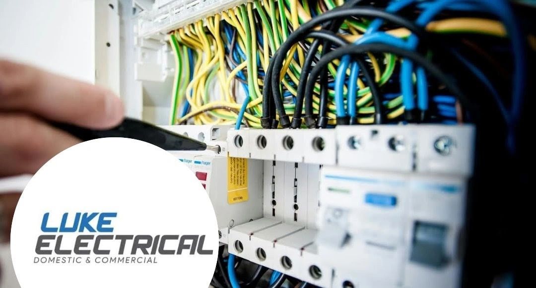 Close-up of electrician working on circuit breakers with colorful wires.