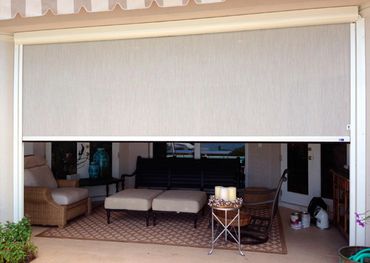 Outdoor patio with a retractable shade, seating, and decorative elements.